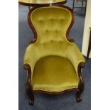 A Victorian mahogany framed armchair, upholstered in later gold buttonback velour,