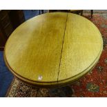 A Victorian mahogany oval loo table, raised on turned column and scroll supports,