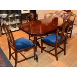 A reproduction mahogany dining table with four Hepplewhite style dining chairs,