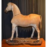 A vintage toy horse, raised on wooden plinth with castors (old worm to plinth base),