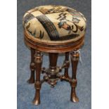 A late Victorian mahogany revolving piano stool, with Art Nouveau upholstery to the top,