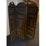 A Burmese hardwood four section folding dressing screen, with pierced foliate panels,