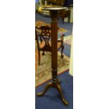 A mahogany torchere, with circular top raised on reeded column and tripod supports,