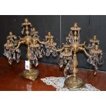 A pair of brass four branch candelabras, with basmatic crystal drops,