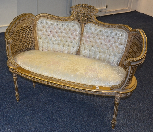 A Regency style gilt painted bergere love settee, upholstered in floral fabric,