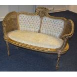 A Regency style gilt painted bergere love settee, upholstered in floral fabric,