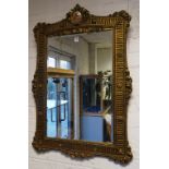 A reproduction gilt wall mirror, with ceramic plaque to top,