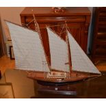 A painted wooden model of the yacht 'Cutty Sark', with three masts,