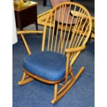 A blonde Ercol rocking chair, with spindle back,