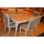 A contemporary painted dining table with six chairs, including two carvers, with one spare leaf,