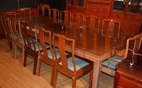 A Chinese hardwood dining table and 10 chairs, the four section panelled top with glass protector,