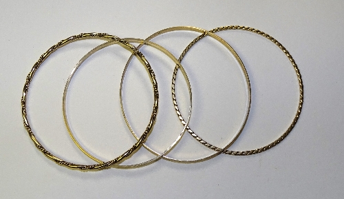 Four 9ct gold bangles, all of different designs, 6.5cm diameter, 23.