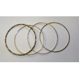 Four 9ct gold bangles, all of different designs, 6.5cm diameter, 23.