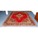 A Tabriz carpet, the large central floral motif on red ground,