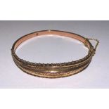 A 9ct gold bangle, with beaded pierced decoration, stamped 375 to underside, 8.