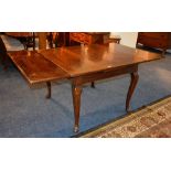 A vintage mahogany pull out extending dining table, raised on pad foot,