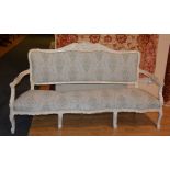 A white painted parlour settee, upholstered in floral fabric,