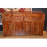 A modern hardwood sideboard, with two small drawers above panelled doors,