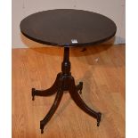 A reproduction mahogany occasional table, with circular top raised on four downswept supports,