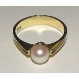 A 15ct gold pearl ring, set with single white pearl to centre, stamped 585 to underside,