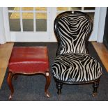 A 19th century mahogany footstool, with later hide top, raised on sabre supports,