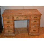 A late Victorian pine kneehole desk, with single drawer, flanked with four small drawers,