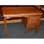 A vintage style oak kneehole desk, with brushing slide above three small drawers,