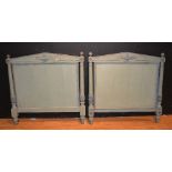A pair of French Empire style painted wood single bed headboards, decorated with urn motifs,