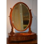 A George III mahogany inlaid dressing mirror, the swing oval mirror raised on three drawer base,