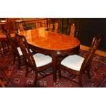 A Chinese walnut veneered dining table with six dining chairs, the table with two additional leaves,