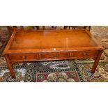 A modern yew wood partners coffee table, with three drawers to each side,