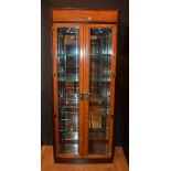 A pair of Chinese walnut veneered display cabinets, with two glazed doors enclosing glass shelves,