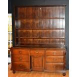 A large vintage oak dresser, with open shelving above central drawer and panelled door,