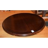 A reproduction mahogany circular lazy susan, raised on brass ball supports,