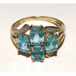 A 9ct gold blue topaz ring, set with four oval cut topazes to the centre,