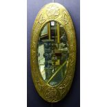 **An Arts & Crafts oval brass wall mirror, with embossed panels of Celtic knotwork design,