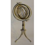 **A chrome and brass 'orbital' desk ornament, raised on turned stem and tripod stylized supports,