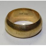 A yellow metal wedding band, stamped '750 18k' to underside, of wide proportions, ring size U, 10.