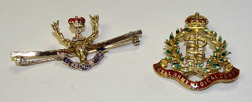 Two gold and enamel military badges,