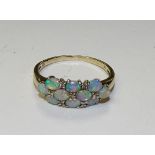 A 9ct gold opal ring, the 10 cabochon oval opals interspersed by milidiamonds,