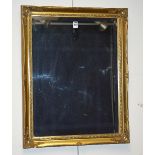 A reproduction gilt and bevelled glass wall mirror,