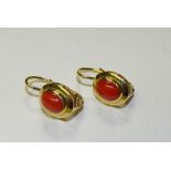 A pair of 18ct gold coral drop earrings, the coral cabochons mounted in gold oval setting,