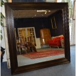 A large modern wooden framed overmantel mirror,