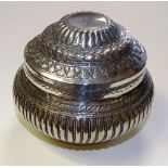 An Eastern white metal jar with lid, with allover foliate decoration and gadrooned sides,