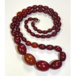 A graduated string of cherry amber beads, 75cm long (unfastened),