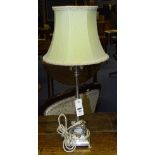 A plated table lamp with shade, decorated with rams head terminals,