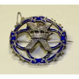 A white metal and blue enamel brooch, in the style of Alexander Ritchie,