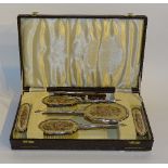 A cased silver and needlepoint six piece brush set, hallmarks for Birmingham 1914 Adie Brothers,