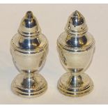 A cased pair of silver salt & pepper pots, hallmarks for Birmingham 2000 B & Co, of urn formation,