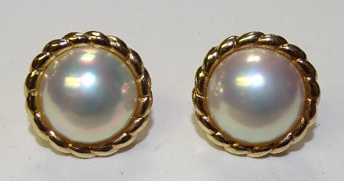 A pair of 18ct gold pearl earrings, the large central white pearl set in frilly gold mount,